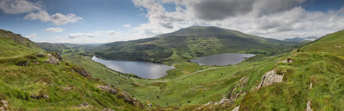 Panoramic view across the twin lakes of Llynnau Mymbyr toward Moel Siabod and Snowdon in Eryri National Park, Wales
