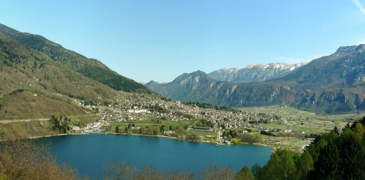 Aerial view of Lake Levico and the town of Levico Terme surrounded by mountains, Valsugana valley, Trentino, Italy