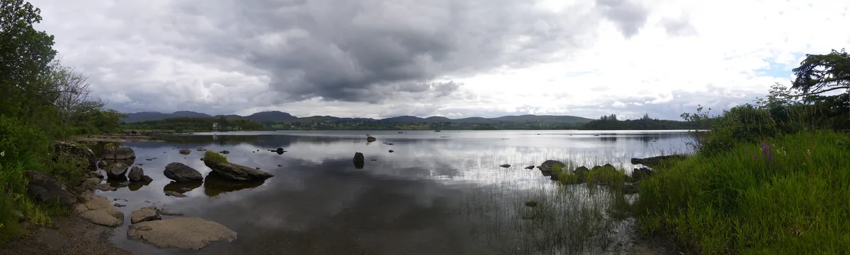 Wide view across the calm waters of Lough Eske towards distant hills