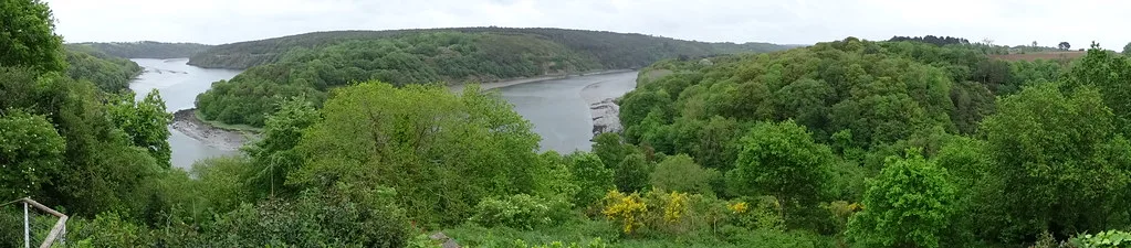 A wide panoramic view of the wooded Trieux river valley with the tidal river visible below.