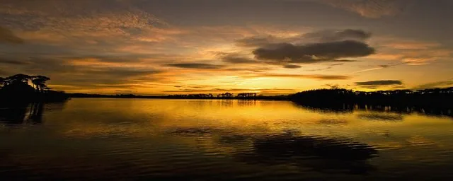 Wide panoramic view of sunset colours reflected in Knockaderry Reservoir, County Waterford, Ireland