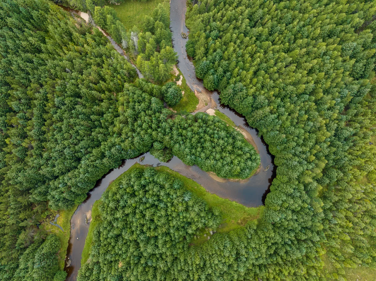 The River Muick flowing through moorland and hills in the Cairngorms National Park, Scotland.