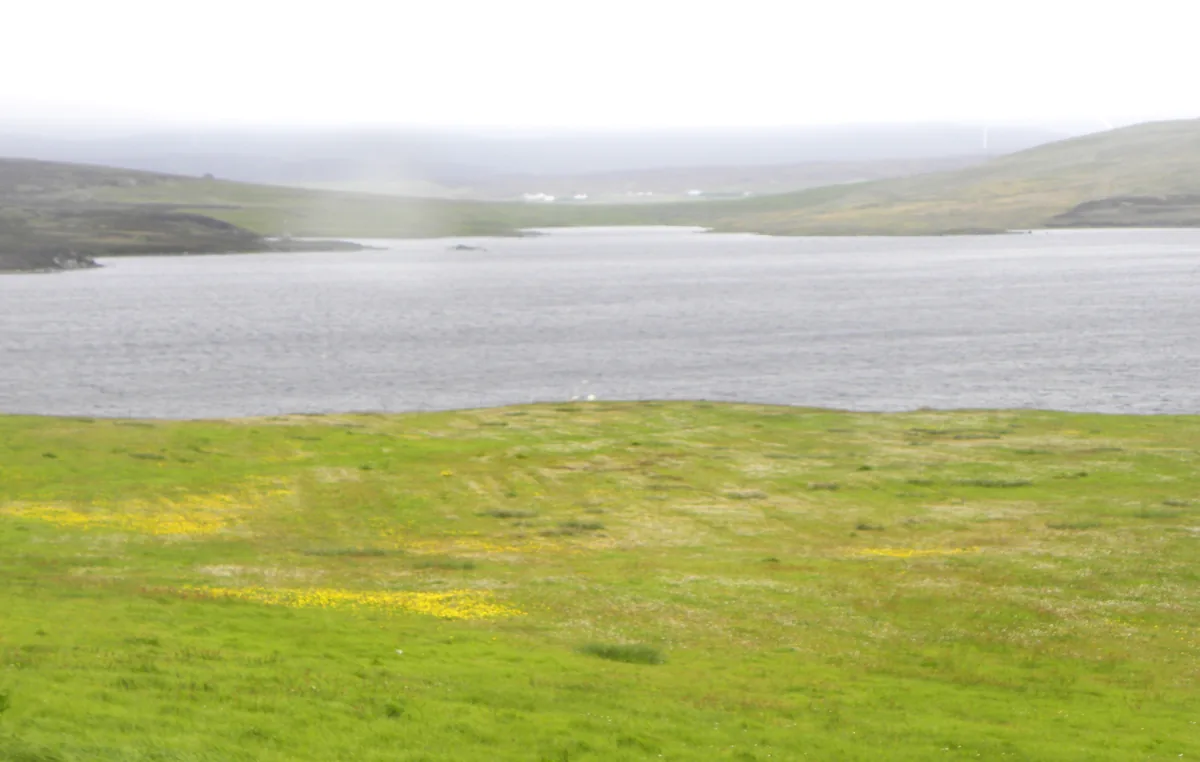 Loch of Vaara, a Shetland freshwater loch between Twatt and Clousta, with moorland shoreline and open sky.