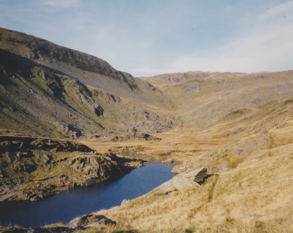 Deep blue upland reservoir (Llyn Cwm Foel) set in a rocky valley with a mountain, Moel Boethwel, behind it, Snowdonia.