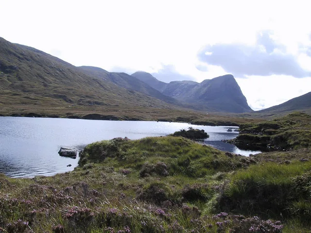 Loch Voshimid, a remote freshwater loch in North Harris, Outer Hebrides, with the hill of Sron Scourst rising behind the water.