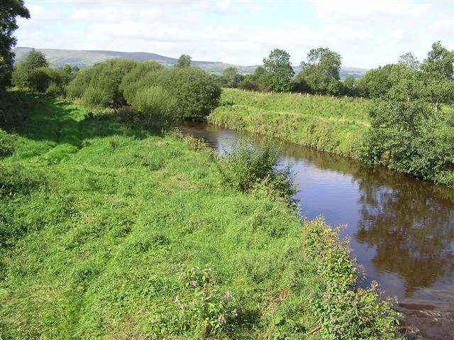 View along the Moyola River in County Londonderry, Northern Ireland, with trees lining the banks.
