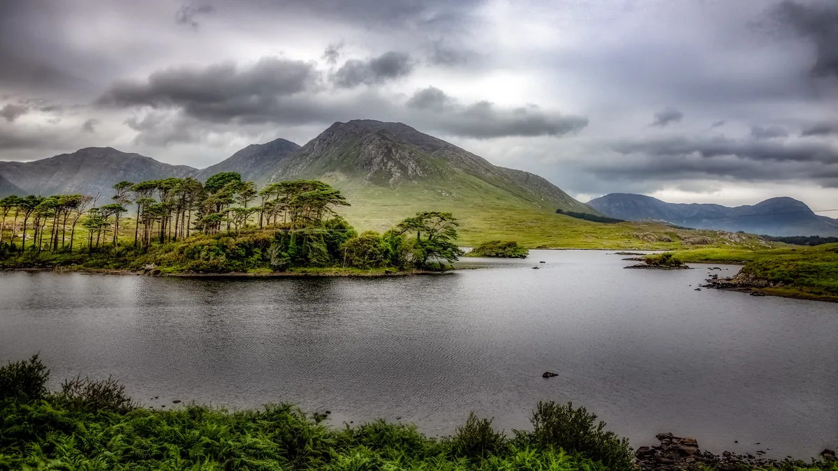 Wide view of Derryclare Lough, a Connemara lake, with the Twelve Bens mountain range in the background.