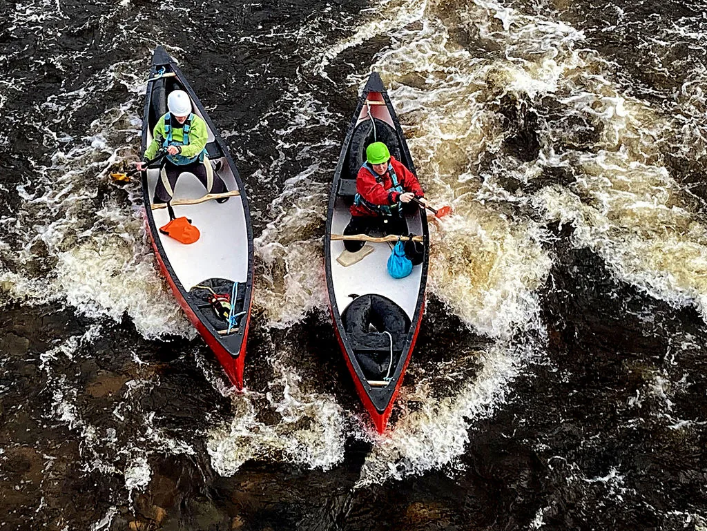 Canoeist paddling on the River Mourne near Newtownstewart, County Tyrone, Northern Ireland, with green riverbanks either side.