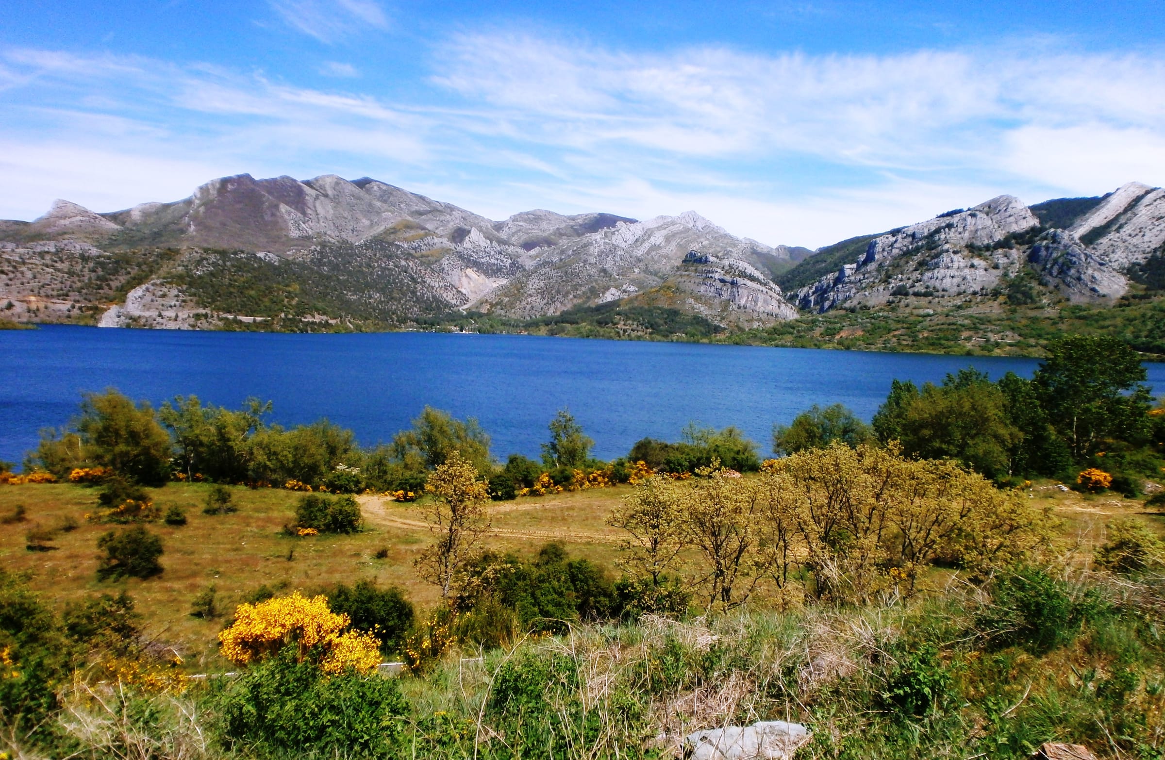 View of Barrios de Luna reservoir with the broad water surface and green mountain slopes of León.