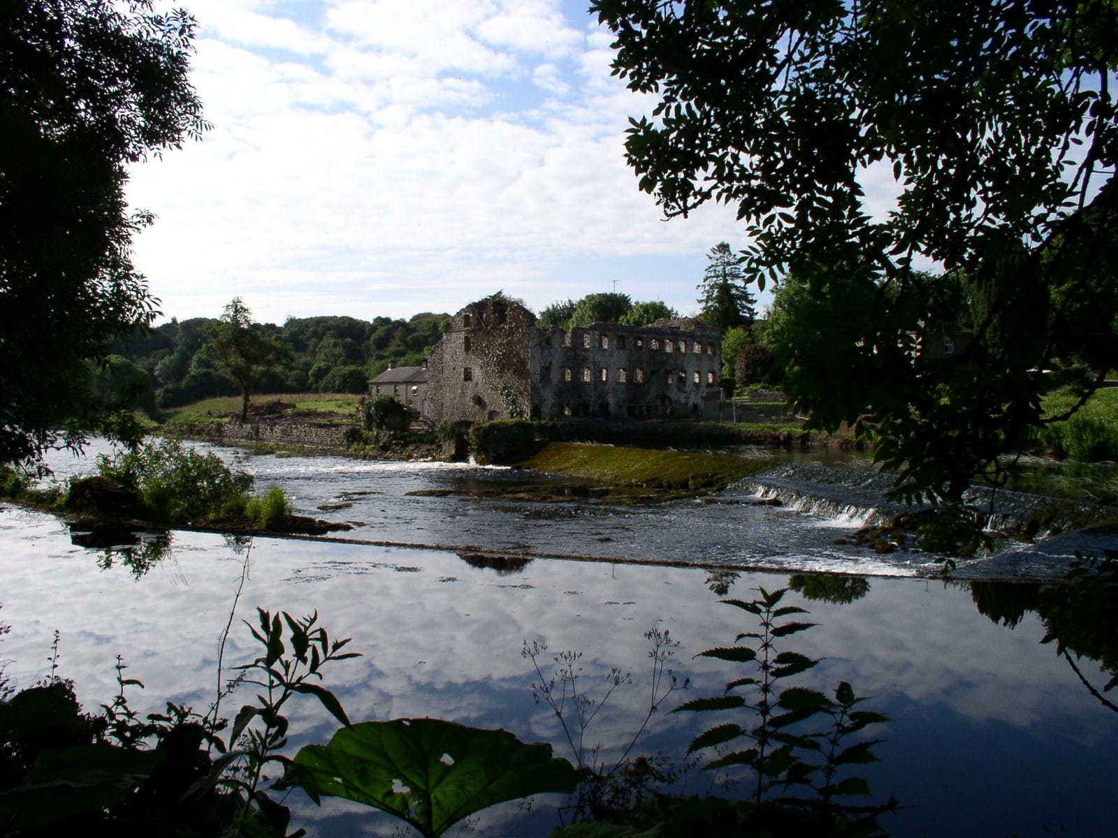 The old mill weir on the River Boyne at Stackallen, County Meath, white water over the stone sill.
