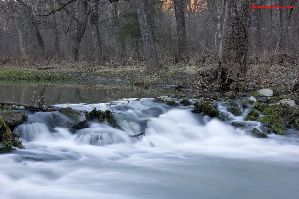 Fast whitewater rapids flowing over rocks in a wooded stretch of the Current River at Montauk State Park, Missouri.