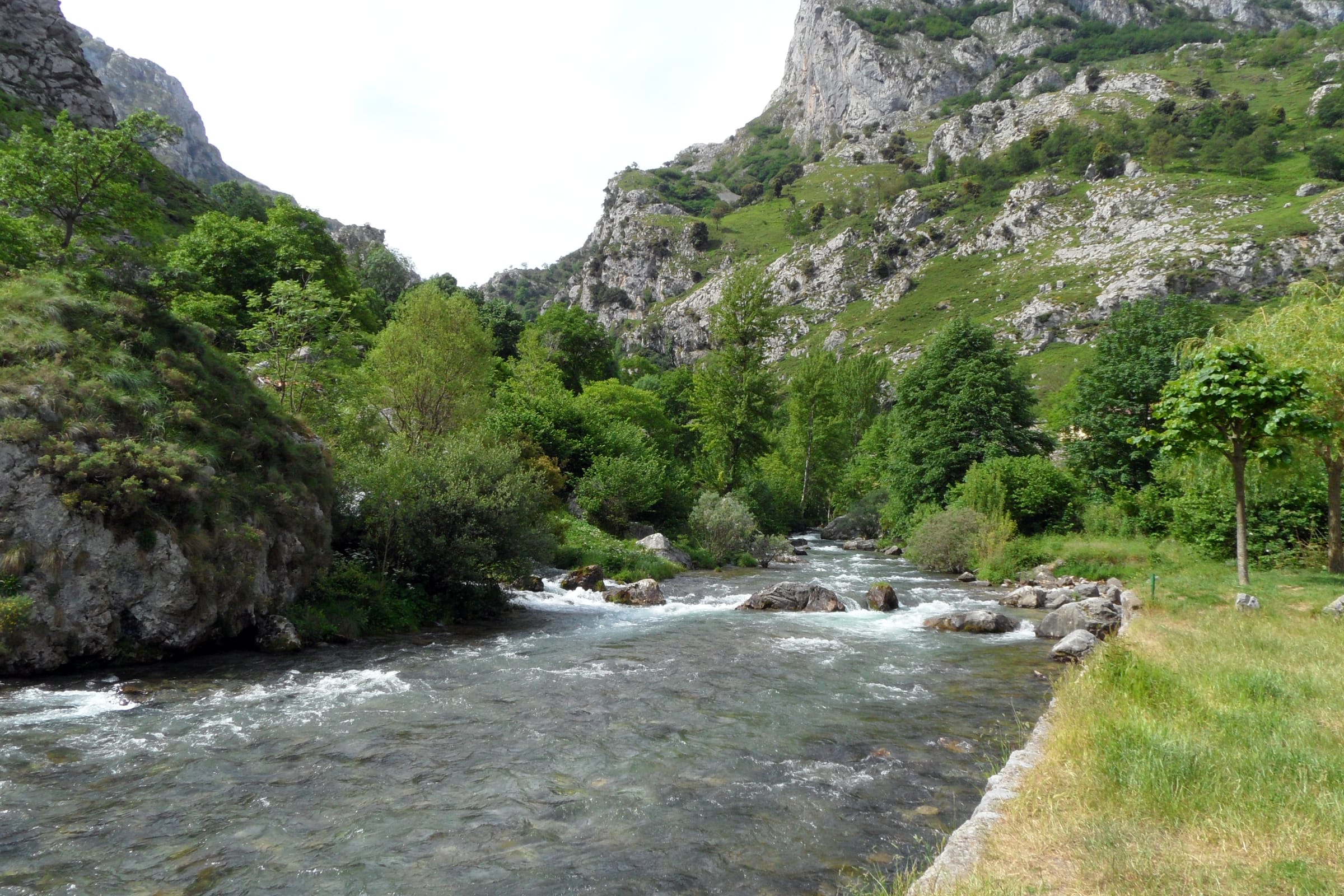 The Río Cares running over boulders and shingle in a wide open valley below Caín de Valdeón.