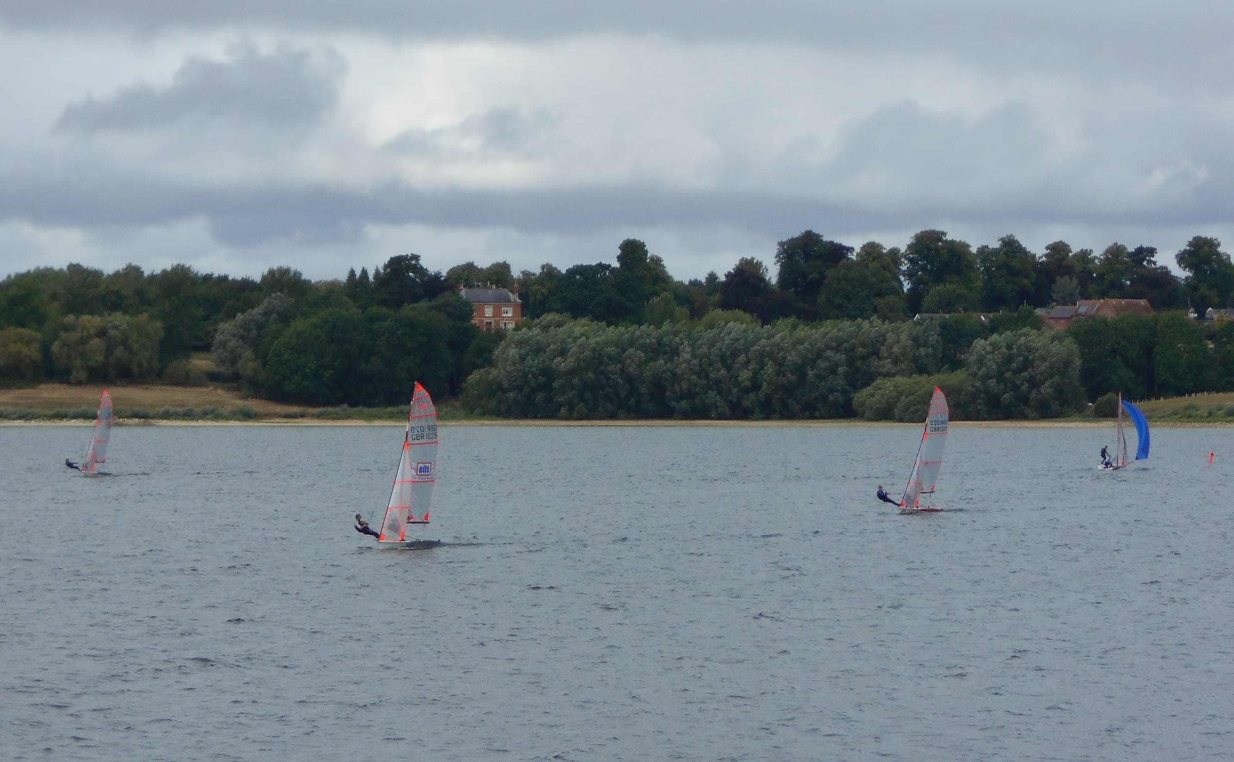 Sailing dinghies on Draycote Water reservoir on a sunny day with open water behind.
