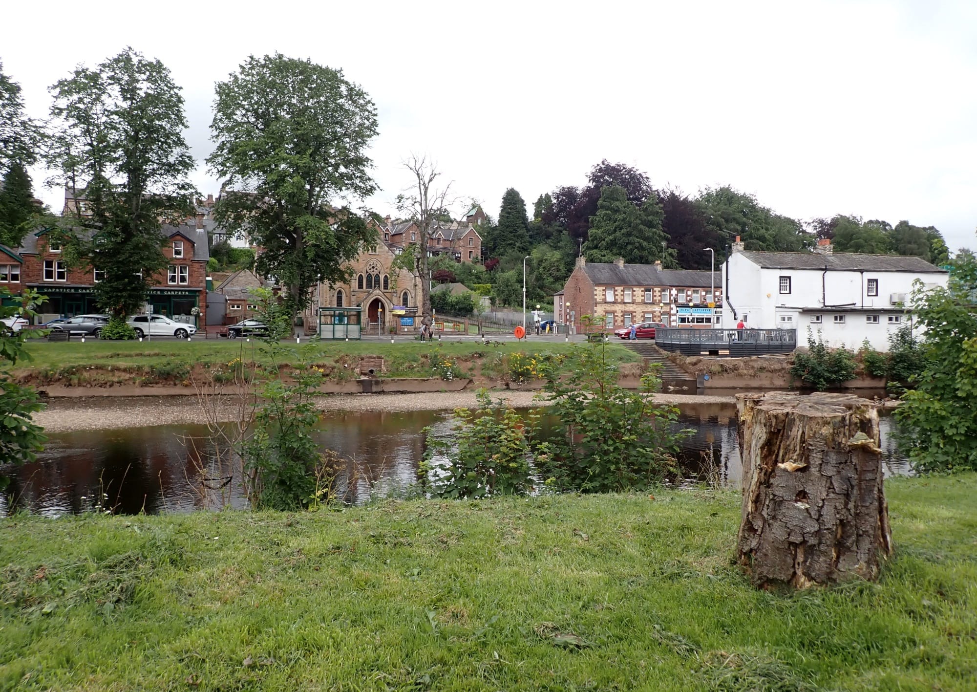 The River Eden flowing through Appleby-in-Westmorland in summer with tree-lined banks and clear water.
