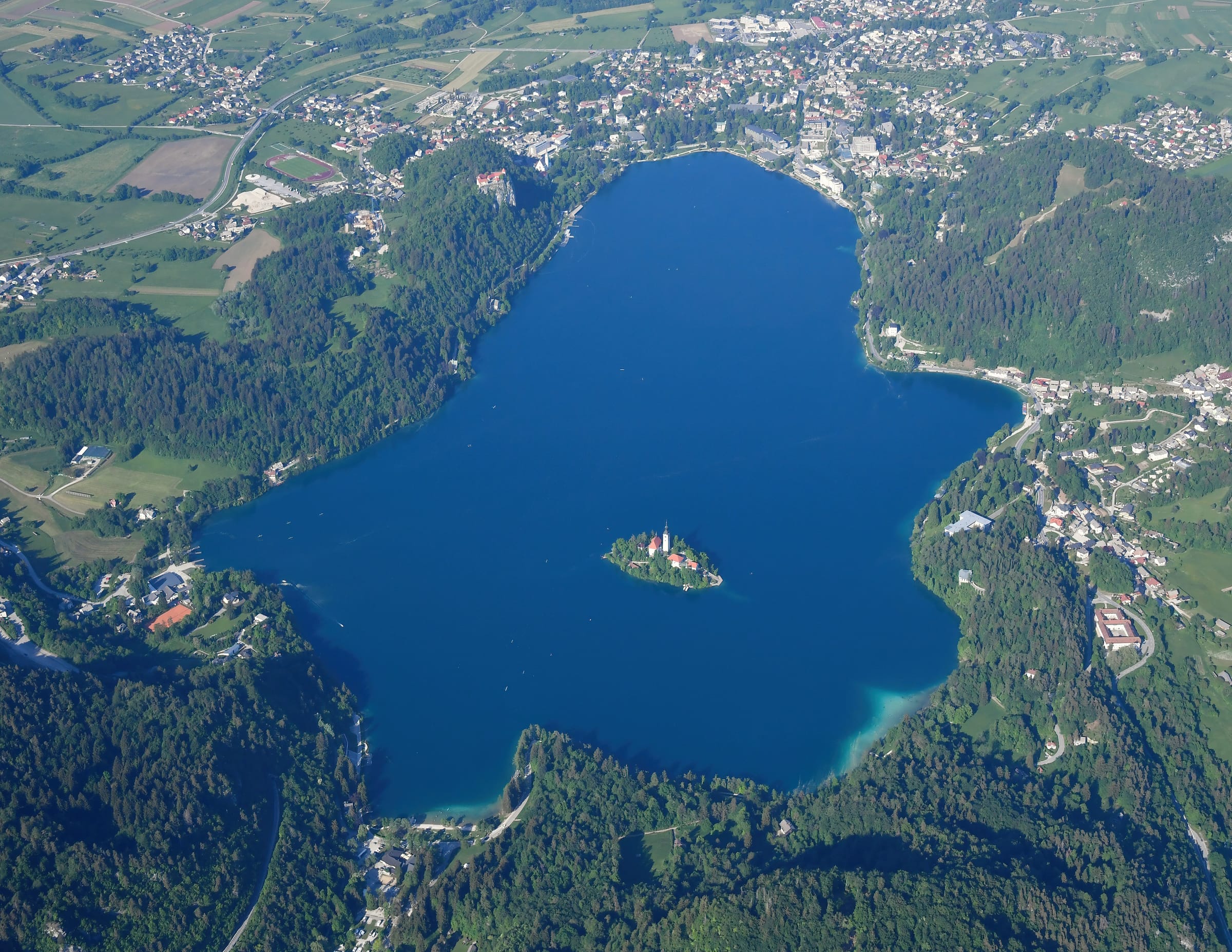 Aerial view of Lake Bled from the southwest, the whole lake, island church, castle cliff and the Julian Alps.