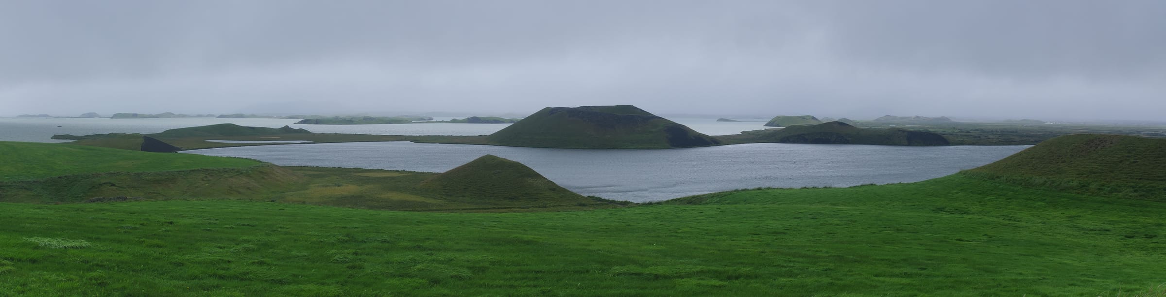 The Skútustaðir pseudocraters rising from the calm surface of Lake Mývatn, Iceland.