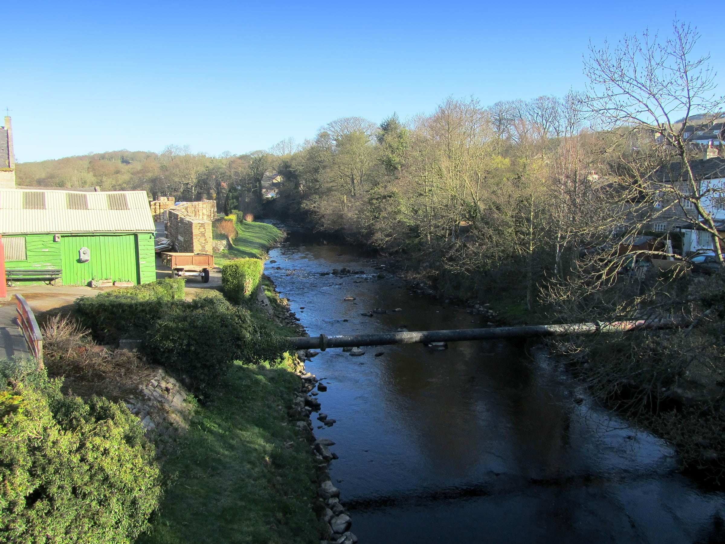 The River Nidd flowing through a wide wooded valley below Summerbridge in Nidderdale in late winter.