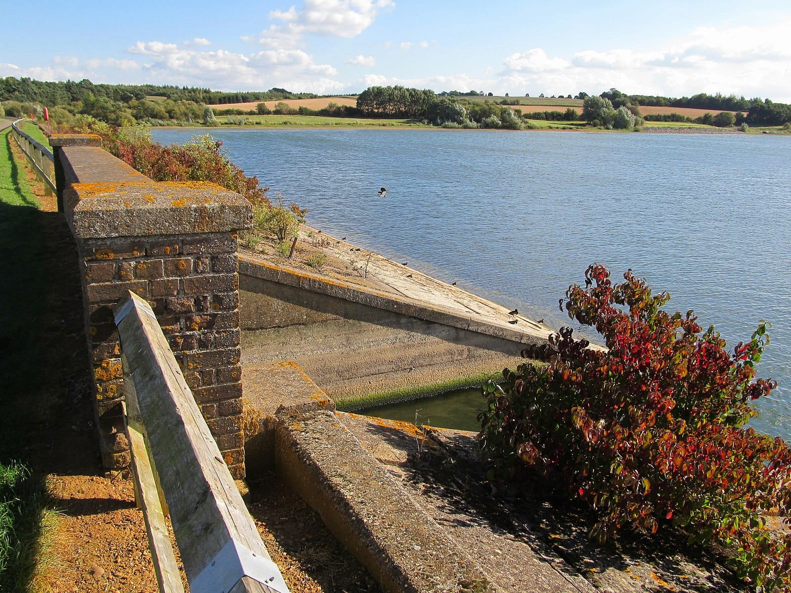 The Brixworth Road causeway crossing Pitsford Reservoir with water on both sides.