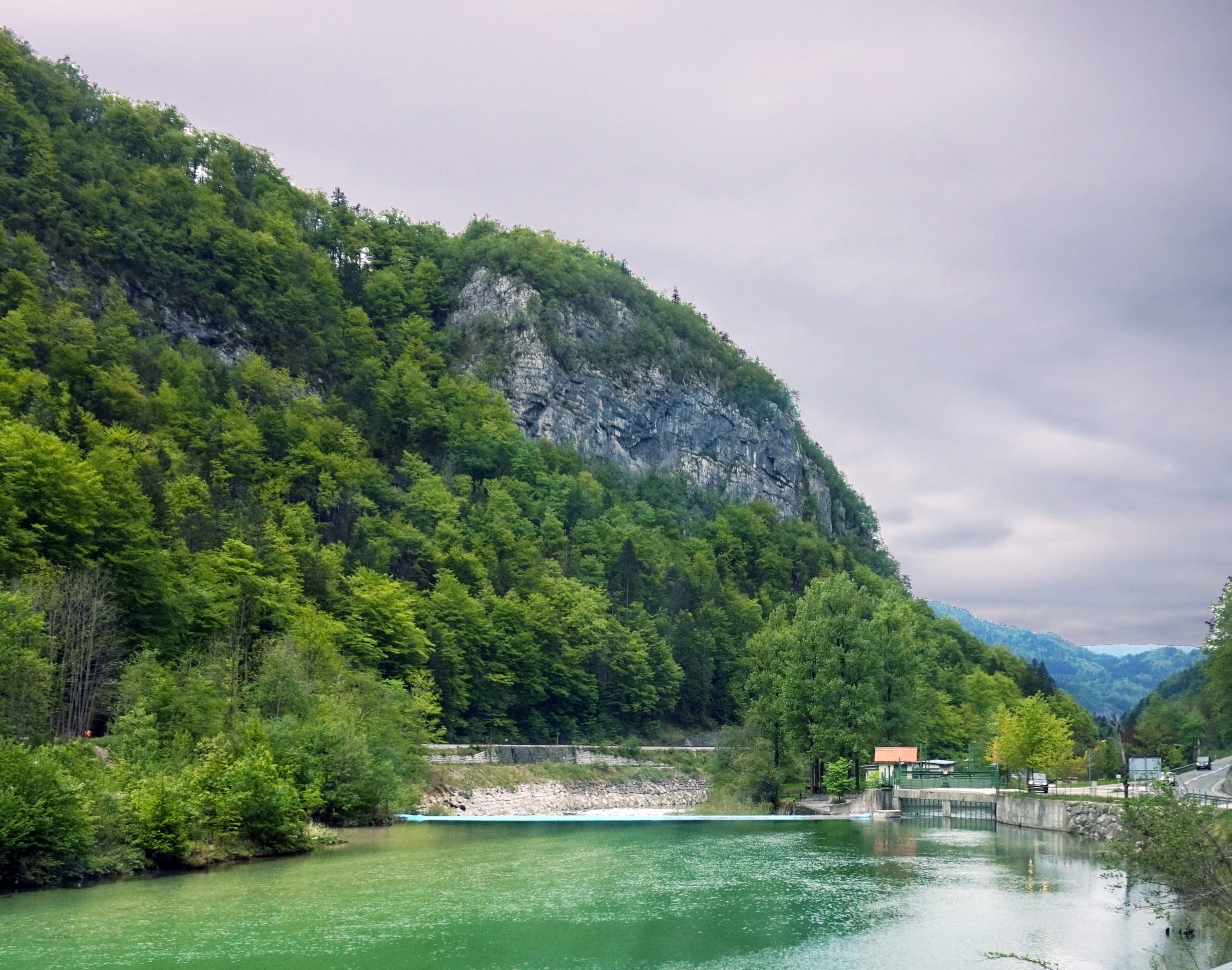 The Sava Bohinjka flowing through a wide gravel-bed valley with alpine mountains behind.