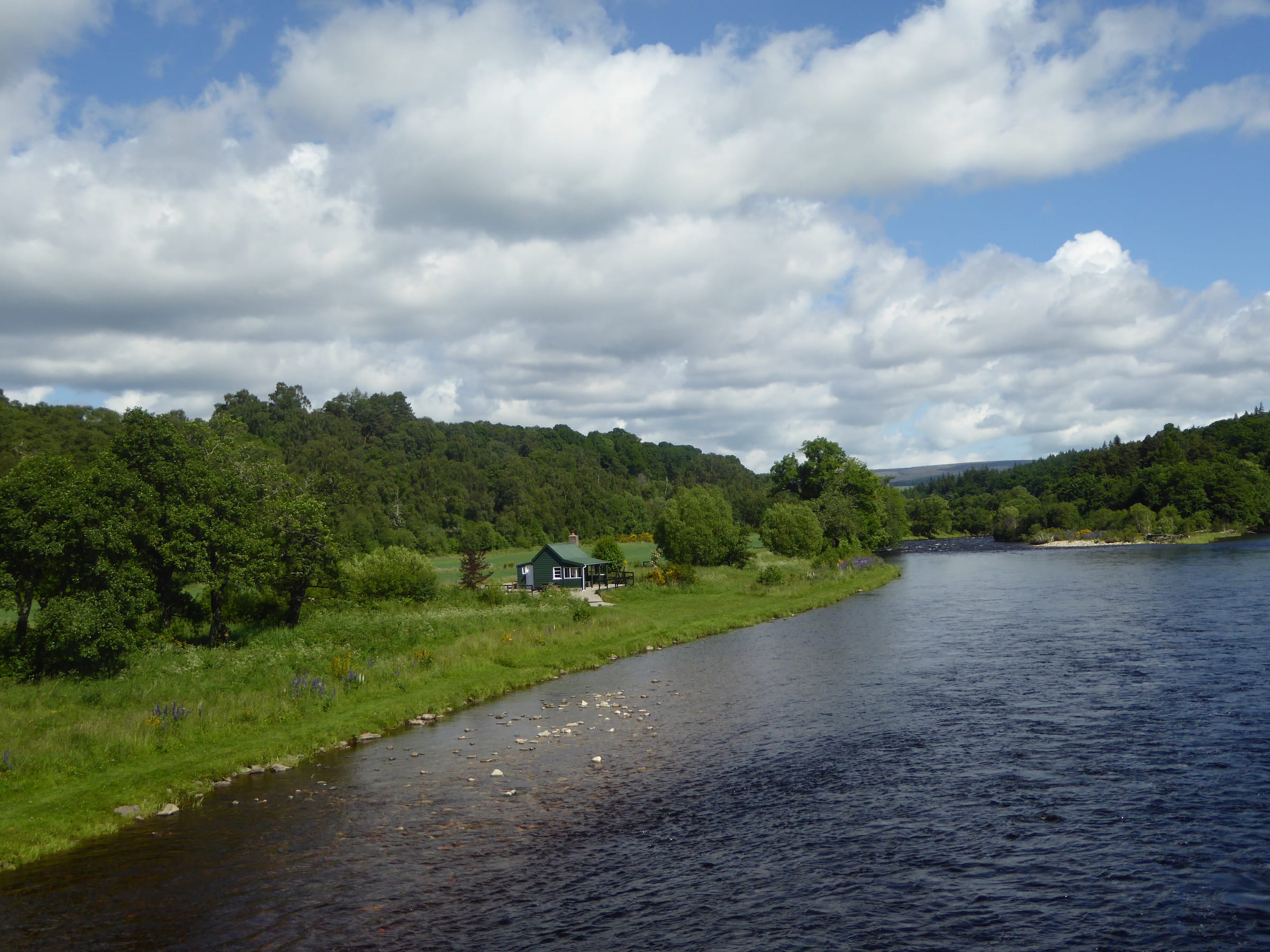 The River Spey at Blacksboat in the Knockando area, wide flow through Speyside landscape under open sky.