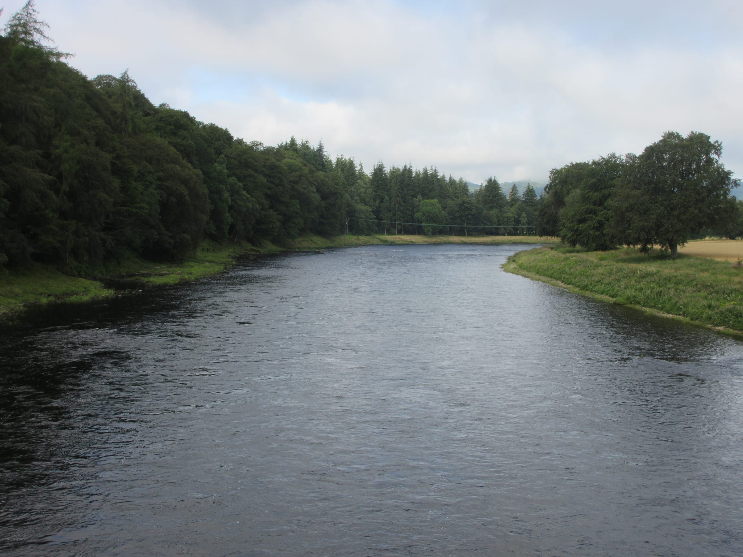 The River Tay viewed downstream from Caputh Bridge on a summer day, the broad calm mid-river.