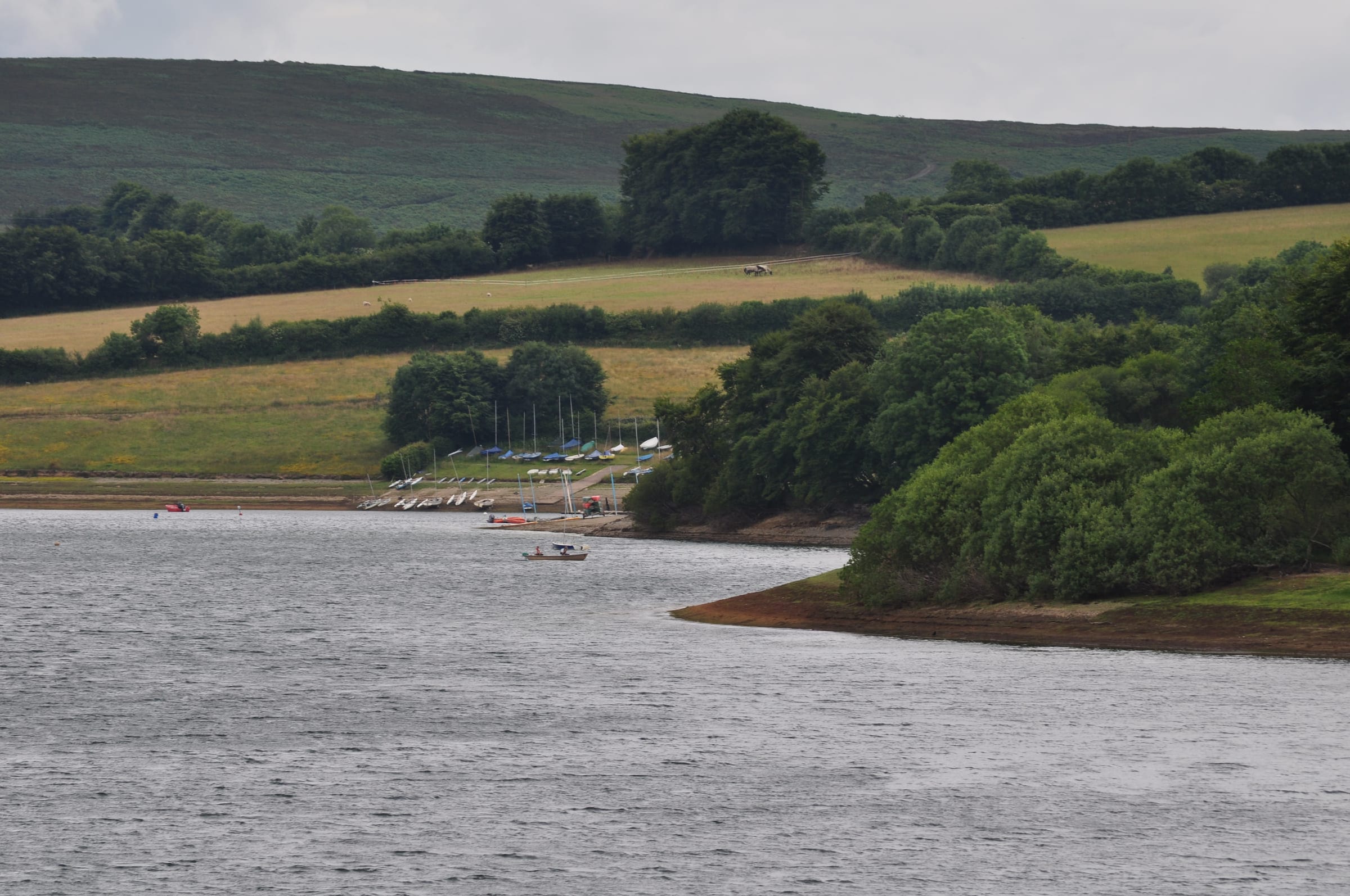 Wimbleball Lake viewed from Berrow Bridge looking back toward the sailing club on the wooded shoreline.